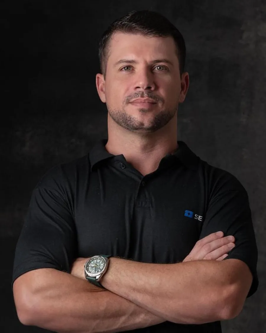 Ronan, criador do Método Seno, de braços cruzados, com camisa polo preta da Seno
